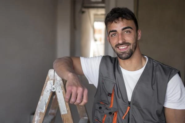 travailleur-smiley-coup-moyen-portant-un-gilet-min
